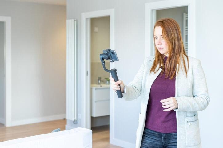An agent photographing a property with a smartphone stabilizer